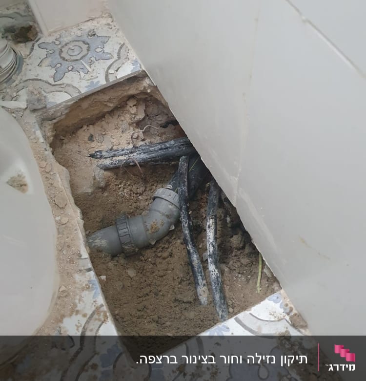 צינור פלסטיק חשוף בתוך חפירה ברצפה